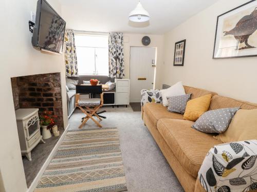 a living room with a couch and a fireplace at Tower View Cottage in Chester