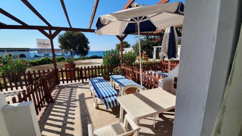 a patio with a table and chairs and an umbrella at Irene Studios in Kefalos