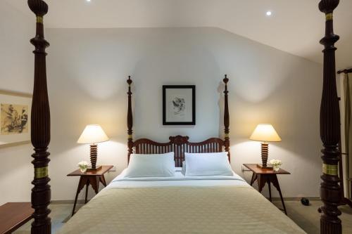 a bedroom with a large bed with two lamps at Nyne Hotels Rock Villa - Bentota in Bentota
