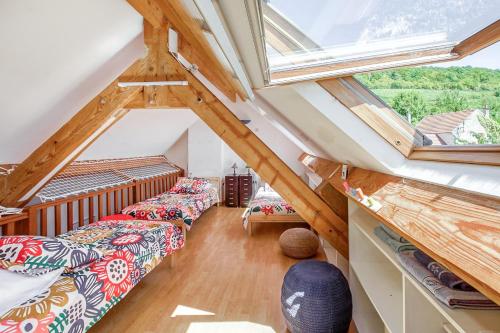 a attic room with two beds and a window at Gîte Leomie - Maison en pierre au pied des vignes - Monthurel in Monthurel