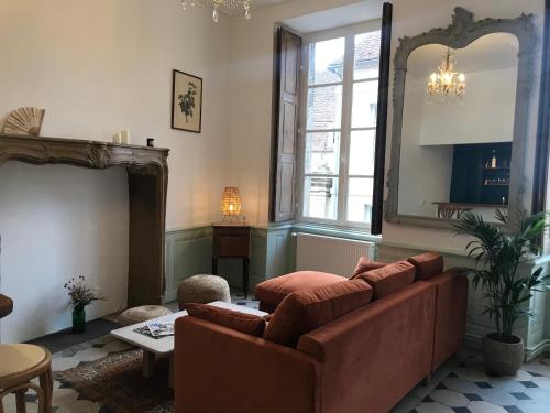 a living room with a couch and a large window at Le Cocand in Autun