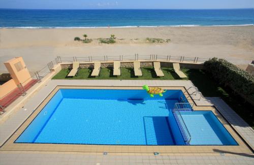an overhead view of a swimming pool next to the beach at Irida beachfront Villa for 12 steps to amenities in Rethymno
