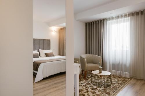 瓦戈斯的住宿－Quinta do Eden，配有一张床和一把椅子的酒店客房