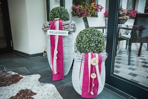 dos jarrones grandes con etiquetas en ellos sentados fuera de una puerta en Hotel Garni Romantika, en Sankt Leonhard im Pitztal