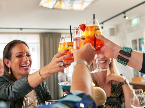 a group of people holding up glasses of drinks at De Maasparel Nextdoor Maassuites in Arcen