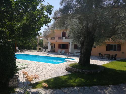 una casa con piscina y un árbol en Calderimi Lefkada en Nydri