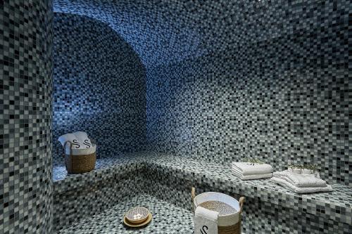 a bathroom with a shower with a blue tiled wall at Seascape Luxury Residences in Agia Pelagia