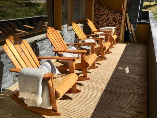 a row of wooden chairs sitting on a porch at Holiday Home Levi hillside by Interhome in Levi