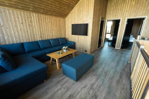 a living room with a blue couch and a table at Risøyhamn Sjøhus AS in Risøyhamn