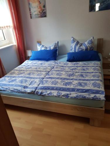 a bed with blue sheets and pillows in a bedroom at Mühlenblick in Klütz