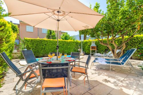 a patio with a table and chairs and an umbrella at Playamar - Private Pool and 150m to Beach in Alcudia