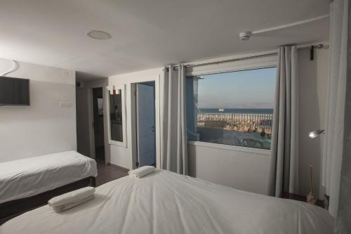 1 dormitorio con 2 camas y ventana grande en South Beach Kinnereth en Tiberias