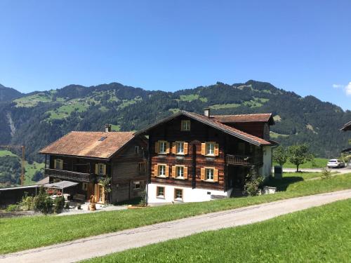 a large wooden house with mountains in the background at Latura - 3.5 Zimmerwohnung für 4 Personen, 80m2 in Buchen