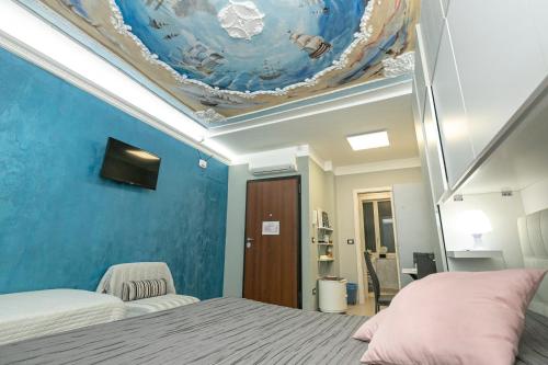 a bedroom with a blue wall with a ceiling at Torre degli Orefici dimora medioevale in Genoa