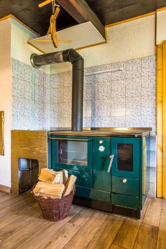 a green stove in a room with a basket at Almhütte Brandgut in Mühlbach am Hochkönig