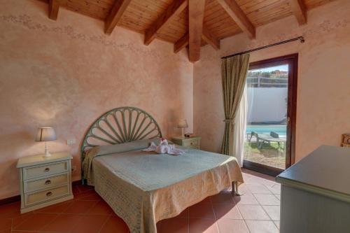 sypialnia z łóżkiem i dużym oknem w obiekcie Sea & Villas w mieście Stintino
