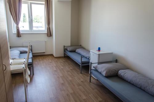 a room with three beds and a window at Ubytovňa Milex in Nové Mesto nad Váhom