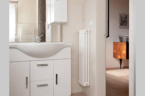 La salle de bains blanche est pourvue d'un lavabo et d'un miroir. dans l'établissement Oriuolo - Terrace with view, à Florence