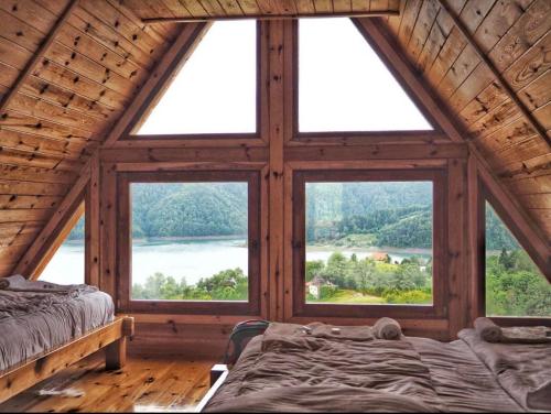 a bedroom with a large window in a log cabin at Zaovinska idila in Bjeluša