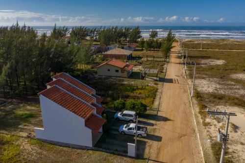 a house with a car parked next to a road at Villas da Jagua in Jaguaruna