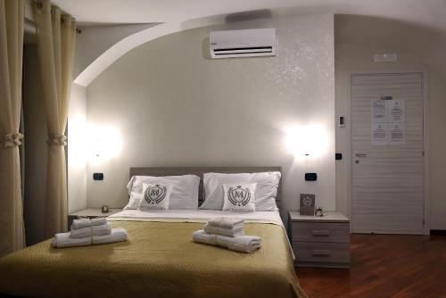 een slaapkamer met een bed met twee handdoeken erop bij Montesantogroup Apartments in Napels