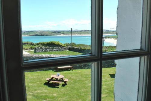 a window view of a picnic table and the ocean at Lellizzick Farmhouse in Padstow
