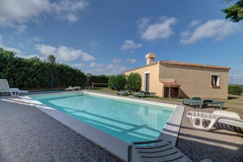 a swimming pool in front of a villa at Sea & Villas in Stintino