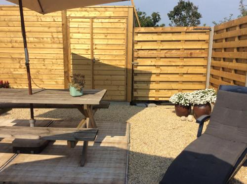a patio with a wooden fence and a table and an umbrella at Ter Ename 3 in Oudenaarde