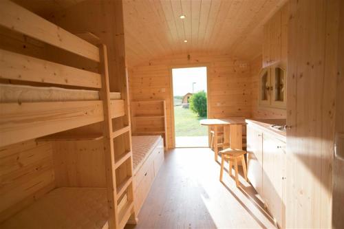 a wooden cabin with bunk beds and a kitchen at Zauberwagen Zirkuswagen Naturwagen in Kröpelin
