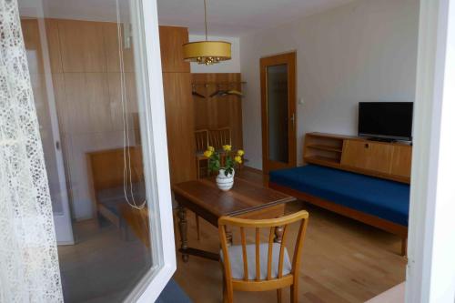 a living room with a table and a room with a bed at Apartment Sonnenlicht in Schruns-Tschagguns