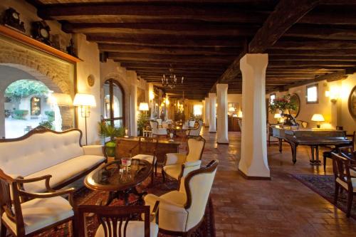 a living room with white furniture and tables and chairs at Hotel Villa Luppis in Pasiano di Pordenone
