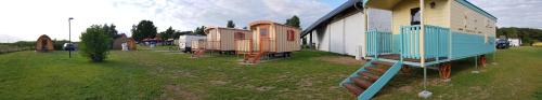 a group of houses in a field next to a building at Zauberwagen Zirkuswagen Naturwagen in Kröpelin