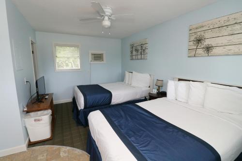 a hotel room with two beds and a flat screen tv at Bird's Nest Resort in Put-in-Bay