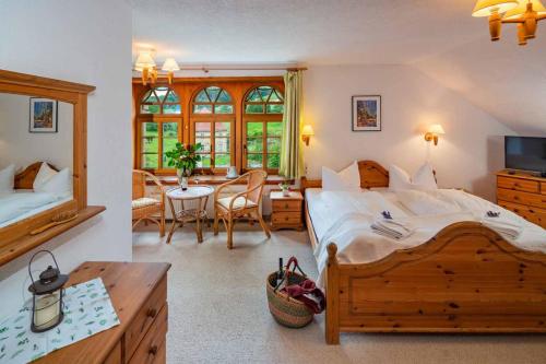 a bedroom with a large bed and a dining room at Landhotel Gut Wildberg mit Sauna in Meißen