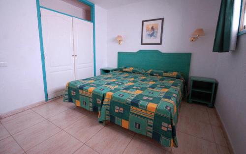 a bedroom with a green bed in a room at Apartamentos Florida Gran Canaria Adults Only in Puerto Rico de Gran Canaria