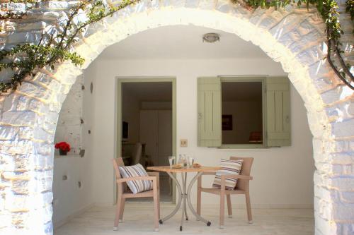an archway in a room with a table and chairs at Saint Andrea Seaside Resort in Naousa