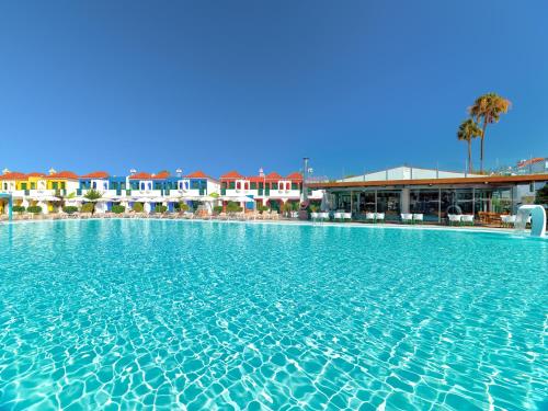 a large swimming pool in front of a hotel at Bungalows Vistaflor in Maspalomas