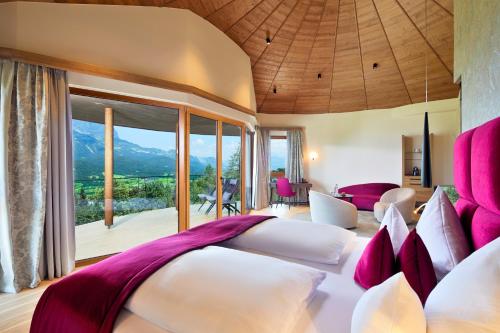 a bedroom with two beds with pink and white pillows at Kaiserhof Superior in Ellmau