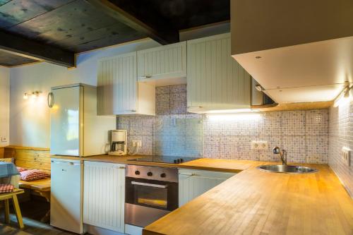 a kitchen with white cabinets and a sink at Almhütte Brandgut in Mühlbach am Hochkönig