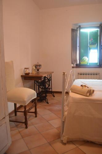 a room with two beds and a table and a chair at Val d'Orcia nel Borgo in Castiglione dʼOrcia
