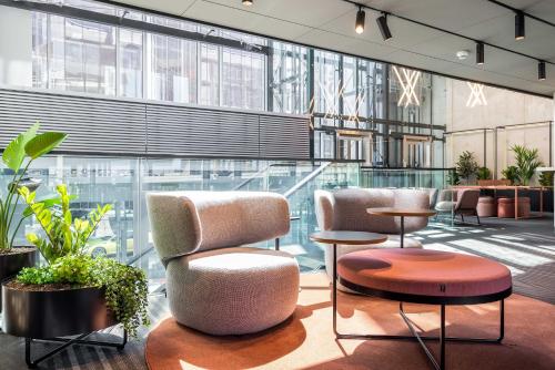 a lobby with chairs and tables and windows at Citybox Tallinn City Center in Tallinn