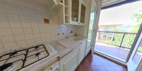 uma cozinha branca com um lavatório e um fogão em Affitto Turistico Via Bonomea 219-1 em Trieste