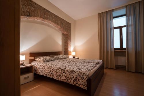 a bedroom with a bed and a brick wall at Old City Apartments in Riga