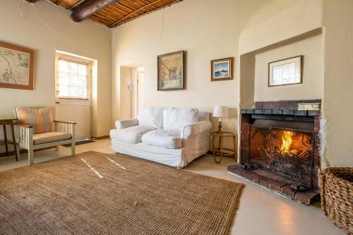 a living room with a white couch and a fireplace at Natte Valleij in Klapmuts