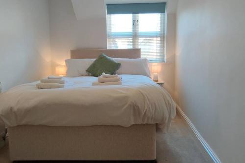 a bedroom with a large bed with two towels on it at Bank House in Lutterworth