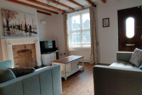 a living room with two couches and a fireplace at Bank House in Lutterworth