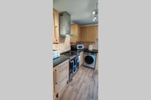a kitchen with wooden cabinets and a stove top oven at Bank House in Lutterworth