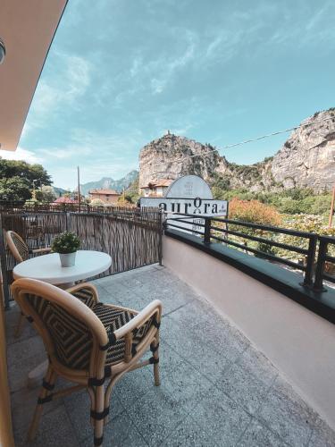 a balcony with a table and chairs and mountains at Hotel Aurora in Arco