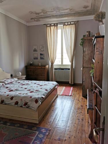 a bedroom with a bed and a large window at In centro da Laura, Via Repubblica 49 BI in Biella