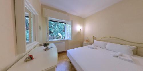 um quarto com uma cama branca e 2 janelas em Affitto Turistico Via Bonomea 219-1 em Trieste